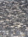 Old grey uneven stone wall made of stacked irregular pieces of rock Royalty Free Stock Photo