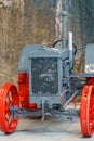 Old grey vintage tractor with red steel wheels