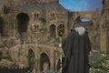 Old grey wizard stands before the bridge to a mystical fantasy castle. 3D illustration