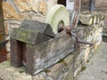 Old grindstone with crank in wooden frame