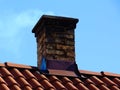 Old decaying chimney on light brown clay tile roof Royalty Free Stock Photo