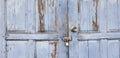 Old grunge or vintage light blue wooden door or window locked with small golden master key for background Royalty Free Stock Photo