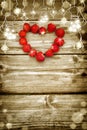 Old grunge wooden board with light bulb border, strawberry in the shape of a heart. Royalty Free Stock Photo