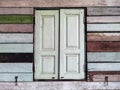 Old grunged wooden window frame painted white vintage with old colourful plywood wall. Antique window frame and old panes. Old