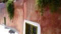 Old grungy pink wall, and decorative Windows on it in Oia