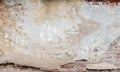 Old grungy red brick wall with peeled beige stucco background. Vintage retro plaster wall with dirty cracked scratched Royalty Free Stock Photo