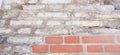 Old grungy red and white brick wall with damaged plaster banner background texture. Royalty Free Stock Photo