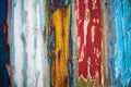 Old grungy weathered colourfully painted wooden wall plank texture in yellow, blue, red and white color mix artistic background Royalty Free Stock Photo