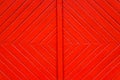Old grungy and weathered red orange painted wooden wall plank door detail with diagonal lines forming squares as simple saturated Royalty Free Stock Photo