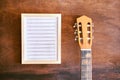 Old guitar on a wooden table. white sheet of musical notes for recording. inspiration concept Royalty Free Stock Photo