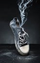 Old gym-shoe in smoke Royalty Free Stock Photo