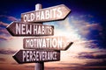 Old habits, new habits, motivation, perseverance - wooden signpost, roadsign with four arrows Royalty Free Stock Photo