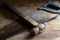 Old hacksaw and hammer on the boards. Royalty Free Stock Photo