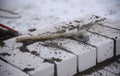 An old hammer lies on the bricks of a construction site.