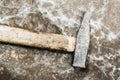 Old hammer on rumpled shabby metal, close-up abstract background