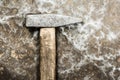 Old hammer on rumpled shabby metal, close-up abstract background