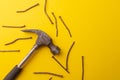 Old hammer and rusty nails. Yellow background. Copy space Royalty Free Stock Photo