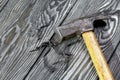 An old hammer and several bent nails of different sizes. On pine brushed boards painted black. World Labor Day Royalty Free Stock Photo