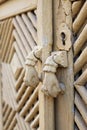 Old hand door-knocker on a wooden door with polygonal ornaments Royalty Free Stock Photo