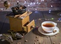 An old hand-held coffee grinder and a porcelain Cup against a brick wall Royalty Free Stock Photo