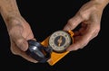 Old hand holding compass, isolated on black background. Royalty Free Stock Photo