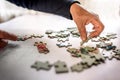 Old hand picking a jigsaw puzzle piece Royalty Free Stock Photo