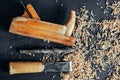 Old hand plane, drill and chisel with wooden shavings on black background. Old woodworking hand tool. Copy, empty space for text Royalty Free Stock Photo