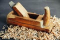 Old hand plane and wood shavings on black background. Old woodworking hand too on a black background. Copy, empty space for text Royalty Free Stock Photo