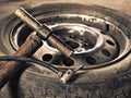 Old hand-pump and car wheel close-up Royalty Free Stock Photo