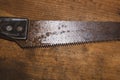 Old hand saw on a dirty wooden background. working area with hand instrument. carpentry tool. manual labor concept Royalty Free Stock Photo