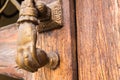 Old hand-shaped knob to knock on an old wooden door Royalty Free Stock Photo