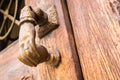 Old hand-shaped knob to knock on an old wooden door Royalty Free Stock Photo