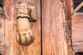 Old hand-shaped knob to knock on an old wooden door Royalty Free Stock Photo