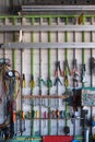 Old hand tools hanging on wall in workshop or auto service garage, many tool shelf against a wall, car mechanic concept.