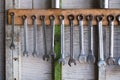 Old hand tools hanging on wall in workshop or auto service garage, many tool shelf against a wall, car mechanic concept.