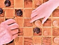 Old hand and young hand playing checkers Royalty Free Stock Photo