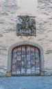 Old handmade medieval wooden gate with a commemorative town seal above in an idyllic small European village