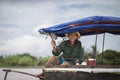 An old and happy fisherman on a fish boat on the Mekong river in Vietnam