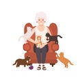 Old happy lady or grandmother sitting in comfy armchair surrounded by cats. Portrait of grandma at home. Smiling female