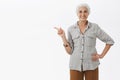 Old happy woman showing her garden with proud and carefree expression holding hand on waist pointing left and smiling Royalty Free Stock Photo