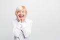 Old but happy woman wears white blouse and showing that she is ery surprised. She has a good luck. on white