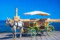 The old harbor of Chania with horse carriages, mosque and lighthouse.