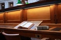 old hard cover book sitting at an old traditional timber reading desk under a glass lamp in an old state library in Melbourne,