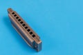 Old harmonica on a blue background. Royalty Free Stock Photo