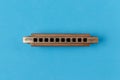 Old harmonica on a blue background. Royalty Free Stock Photo