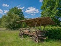 An Old Hay Cart With Wooden Wheels And Wooden Roof