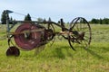Old hay tedder machine on a meadow