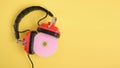 old headphones and pink cd disk on yellow background copy space Royalty Free Stock Photo