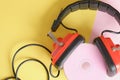 old headphones and pink cd disk on yellow background copy space Royalty Free Stock Photo