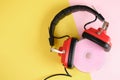 old headphones and pink cd disk on yellow background copy space Royalty Free Stock Photo